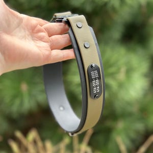 Puede incluir: Un collar para mascotas de dos tonos con una banda interior gris oscuro y una capa exterior color canela. Incluye una placa de identificaci&oacute;n de metal negro con el texto grabado en blanco 414-315-5555 y 414-333-5555, asegurada con remaches negros.