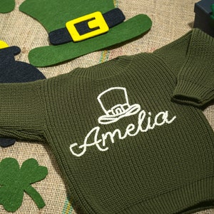 a green sweater with a hat and name on it