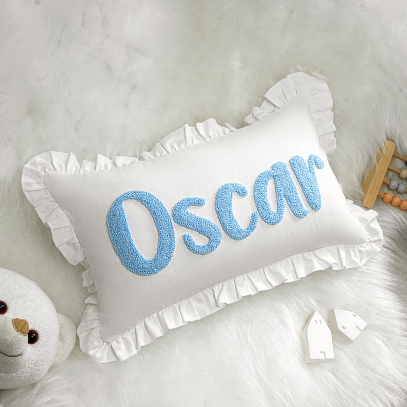 a stuffed animal next to a pillow with the word oscar on it