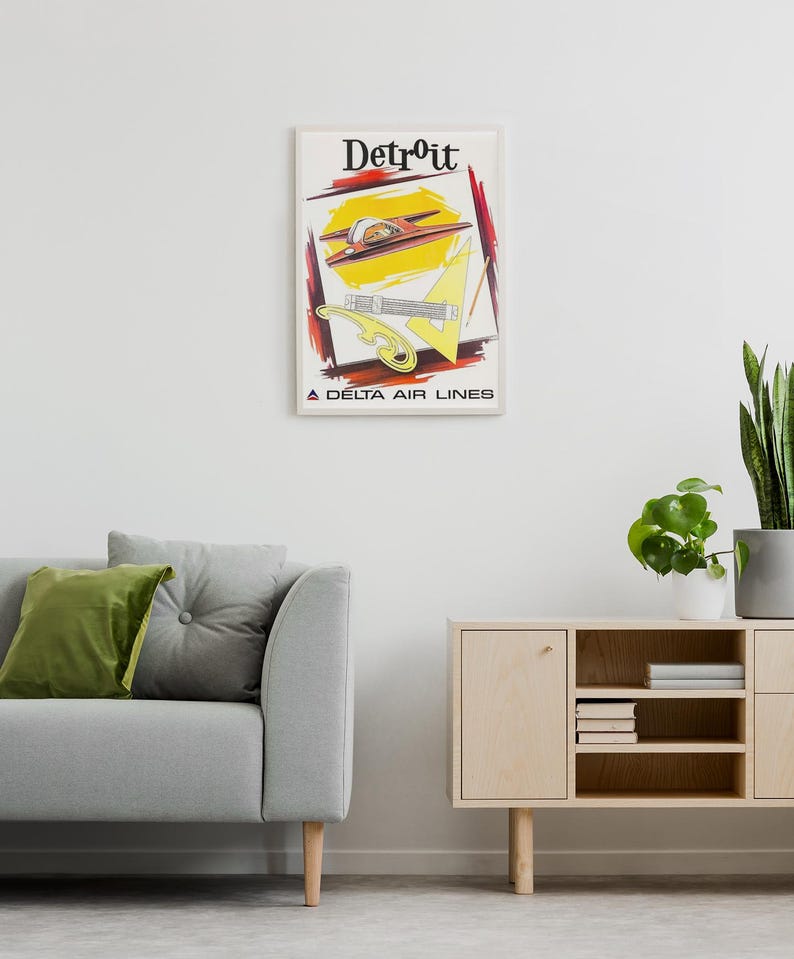 Puede incluir: Un p&oacute;ster de viaje vintage enmarcado de Detroit por Delta Air Lines. La ilustraci&oacute;n presenta un avi&oacute;n rojo, una regla triangular amarilla, una curva francesa amarilla y un l&aacute;piz sobre un fondo blanco con trazos abstractos rojos y negros.