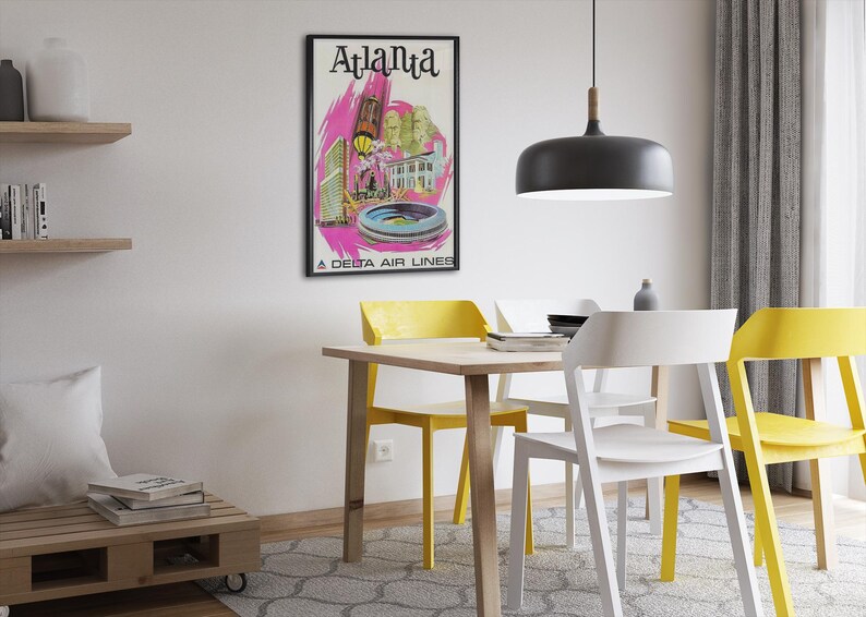 Puede incluir: Un p&oacute;ster de viaje de estilo vintage enmarcado con el texto Atlanta y A Delta Air Lines en la parte inferior. La obra muestra ilustraciones estilizadas de edificios de la ciudad y un estadio en tonos rosa, amarillo y verde sobre fondo blanco.