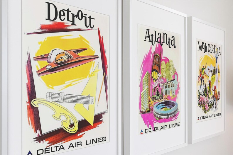 Puede incluir: Tres p&oacute;steres de viaje enmarcados de Delta Air Lines. El primero muestra Detroit con un veh&iacute;culo rojo, un tri&aacute;ngulo amarillo y herramientas de dibujo. El segundo presenta Atlanta con detalles en rosa y monumentos. El tercero ilustra Carolina del Norte.