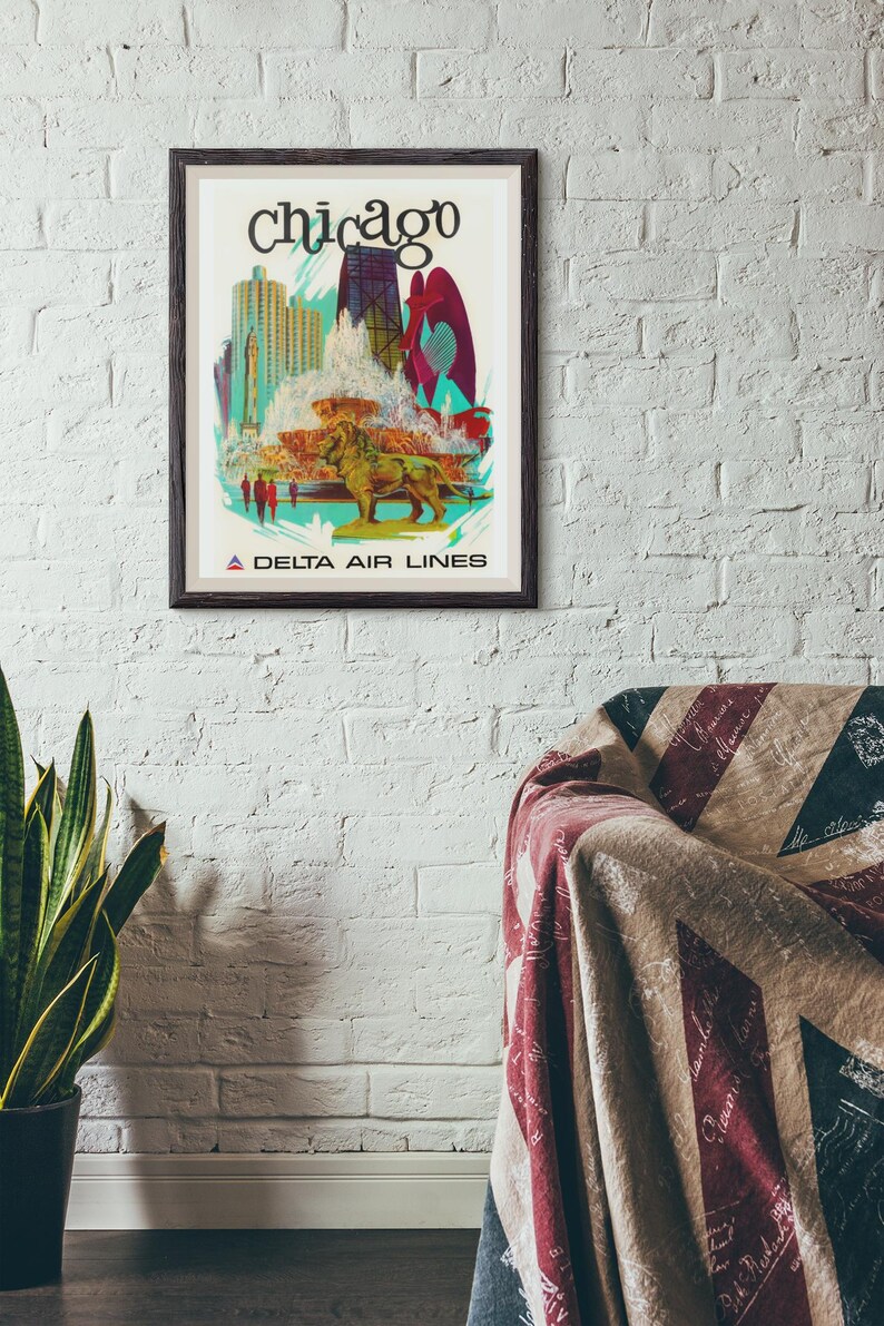 Puede incluir: Un p&oacute;ster de viaje enmarcado de Chicago con una ilustraci&oacute;n estilizada del horizonte de la ciudad, una gran fuente y una estatua de le&oacute;n de bronce. El texto dice Chicago en la parte superior y A Delta Air Lines en la parte inferior.