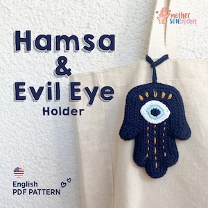 Puede incluir: Patrón de crochet para una mano de Hamsa con un amuleto de ojo turco. El patrón está disponible en inglés y es una descarga PDF. La imagen muestra una mano de Hamsa tejida a crochet con un amuleto de ojo turco colgando de una bolsa de mano.