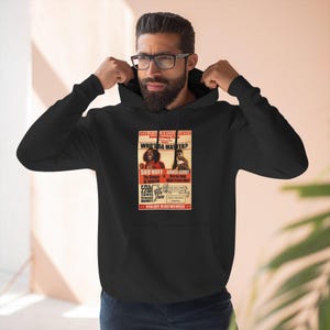 May include: Black hoodie featuring a vintage-style poster with the text "WHO'S DA MASTER?" and images of two men. The poster includes the names "SHO'NUFF" and "BRUCE LEROY" with event details. The hoodie has a drawstring hood.