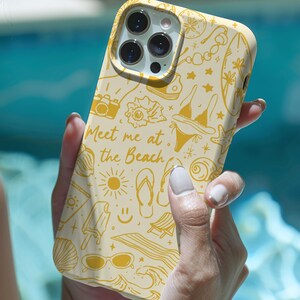 May include: A yellow and white phone case with a beach theme. The case has a variety of illustrations including a sun, a flip flop, a popsicle, and the text "Meet me at the beach".