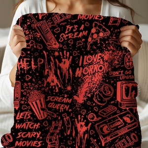 May include: Black blanket with a red horror movie theme. The blanket features various graphics, including a pizza slice, popcorn, and the text "I Love Horror." Other text includes "Scream Queen" and "Hello."