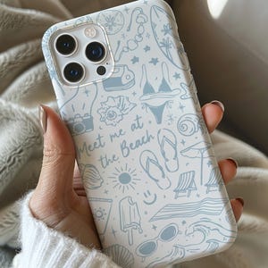 K&ouml;nnte beinhalten: Eine wei&szlig;e Handyh&uuml;lle mit einem hellblauen Strandmuster. Das Design umfasst Illustrationen von Bikini, Sonnenbrille, Flip-Flops und dem Text "Meet me at the Beach."