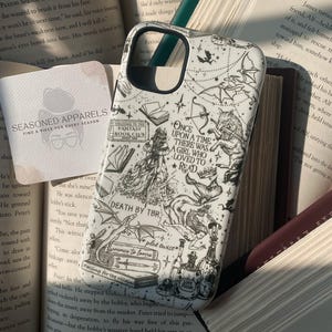 May include: A white phone case featuring black line art illustrations of fantasy elements including dragons, books, a wolf, a mermaid, and potion bottles. The text reads: Once upon a time there was a girl who loved to read, Death by TBR, plot twist, enemies to lovers, and falling for the villain.