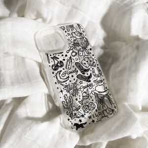 Puede incluir: Funda transparente para tel&eacute;fono con un dise&ntilde;o en blanco y negro con tem&aacute;tica del Oeste. La funda presenta ilustraciones de botas de vaquero, un cactus, un longhorn, una herradura y la palabra "Wild".