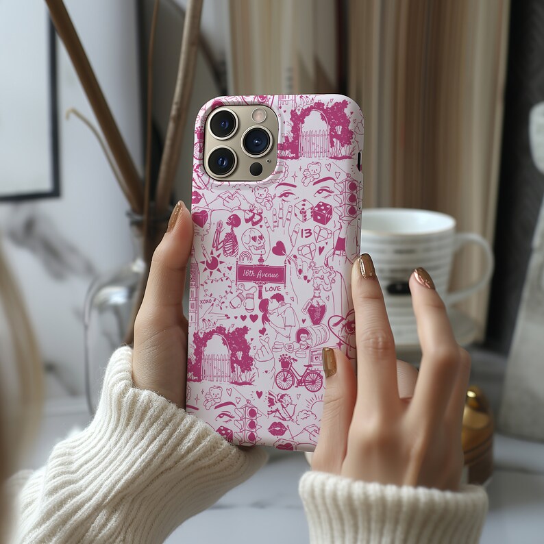 May include: A pink iPhone case with a white background and a pink and white design. The design includes hearts, stars, a skeleton, a dice, a bicycle, and the text "18th Avenue" and "Love".