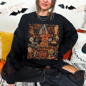 May include: A black sweatshirt with a colorful Halloween-themed graphic print. The print features a skeleton, pumpkins, ghosts, and other spooky elements. The text "Long Live Halloween" is included in the design.