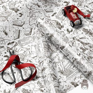 May include: White wrapping paper with a black fantasy illustration, featuring dragons, books, and stars. A red toy car and scissors with a red ribbon are on the paper. The text "DEATH BY TB" is visible on the paper.