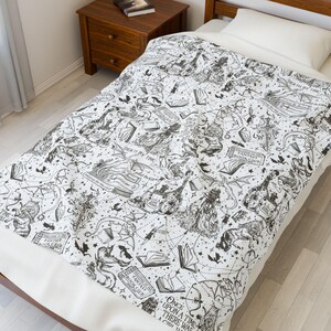 May include: Black and white bedding with a whimsical design featuring a variety of illustrations, including books, dragons, and stars. The text "Once upon a time there was a child" is visible in the lower right corner.