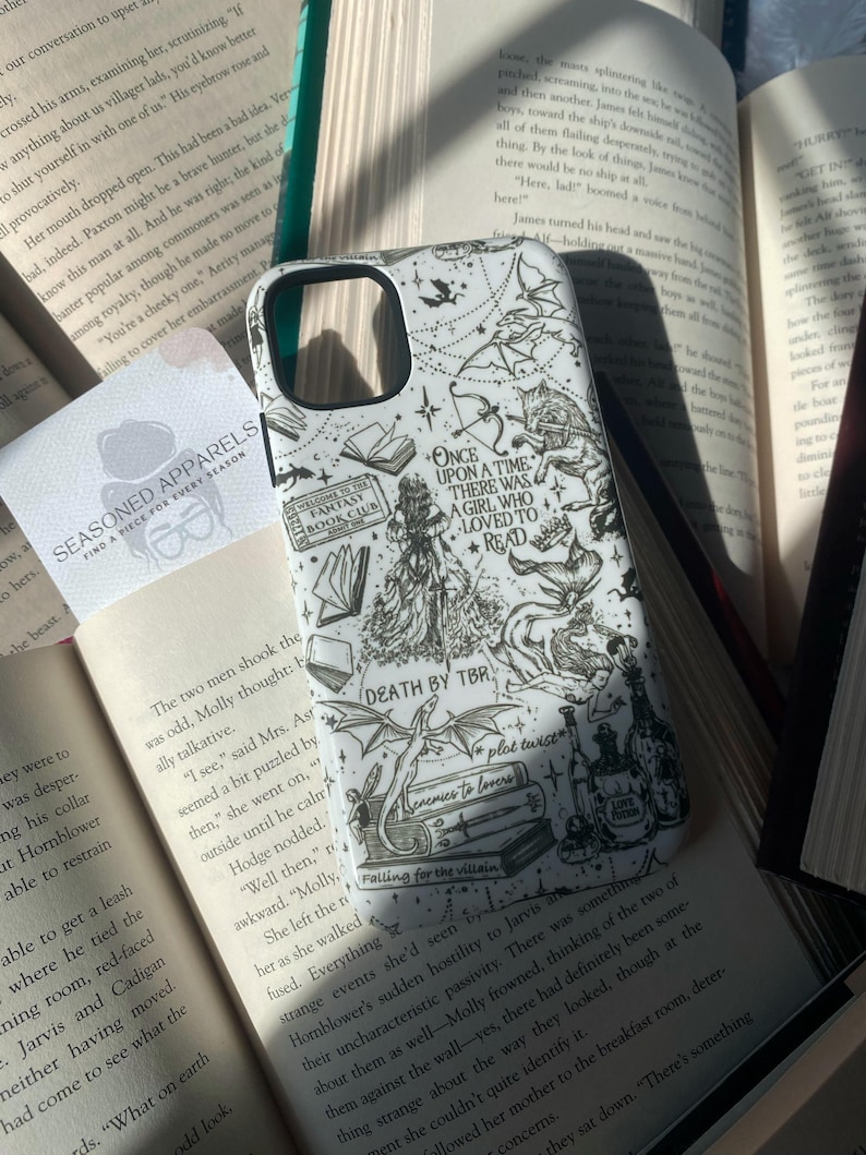 May include: A white smartphone case featuring black line art illustrations of fantasy elements, including a dragon, books, and text that reads Once Upon a Time There Was a Girl Who Loved to Read, Death by TBR, and other literary-themed phrases.