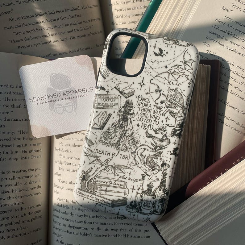 May include: A white phone case featuring black line art illustrations of fantasy elements including dragons, books, a wolf, a mermaid, and potion bottles. The text reads: Once upon a time there was a girl who loved to read, Death by TBR, plot twist, enemies to lovers, and falling for the villain.