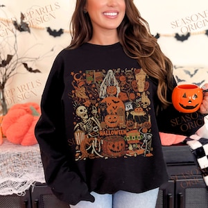 May include: Black long-sleeved sweatshirt with a vintage Halloween graphic print featuring pumpkins, ghosts, skeletons, and the text "Fall is here" and "Long Live Halloween".