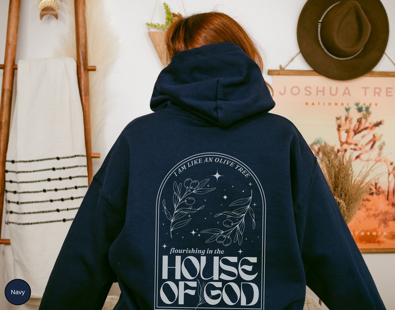 Puede incluir: Sudadera con capucha azul marino con un dise&ntilde;o gr&aacute;fico blanco que representa un olivo con el texto "Soy como un olivo que florece en la casa de Dios".