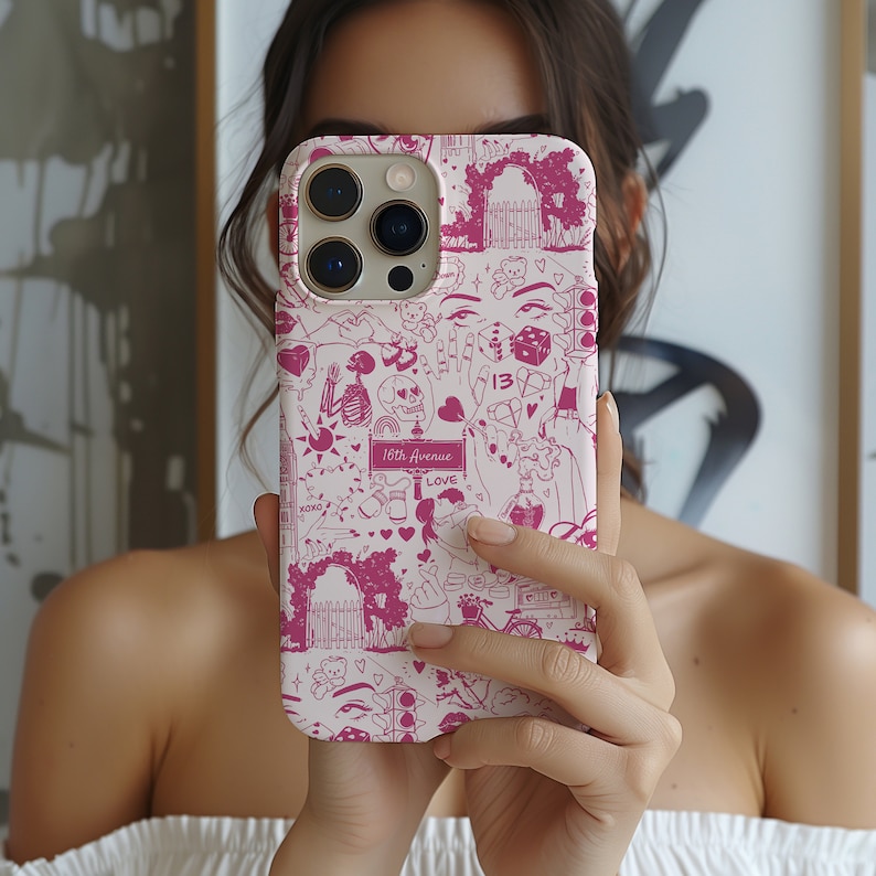 May include: A white iPhone case with a pink and white design. The design features a variety of illustrations including hearts, a skull, a skeleton, a dice, a bear, a gate, a street sign that reads '16th Avenue', and the word 'LOVE'.