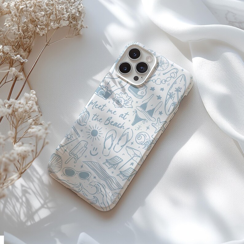 K&ouml;nnte beinhalten: Wei&szlig;es iPhone-Case mit hellblauem Strandmuster. Das Design umfasst Illustrationen von Muscheln, Sonnenbrillen, einer Kamera und den Text "Meet me at the Beach."