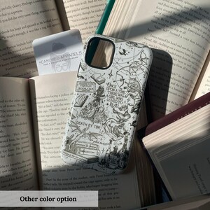 May include: White phone case with a black and white illustrated design featuring a girl, books, and text. The case is surrounded by open books. Text on the case reads "ONCE UPON A TIME THERE WAS A GIRL WHO LOVED TO READ".