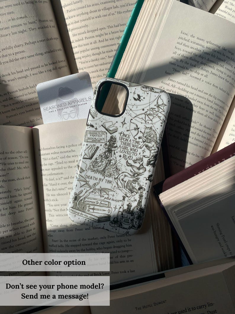 May include: White phone case with a black and white illustrated design featuring a girl, books, and text. The case is surrounded by open books. Text on the case reads "ONCE UPON A TIME THERE WAS A GIRL WHO LOVED TO READ".