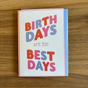 May include: A birthday greeting card with the words "BIRTH DAYS are the BEST DAYS" in colorful, bold letters. The card has a white background with a pink border and a light blue envelope.