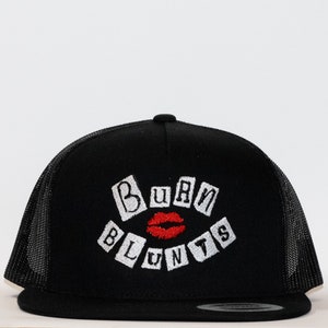 May include: Black trucker hat with a white embroidered design that says "BURN BLUNTS" with a red lip in the middle.