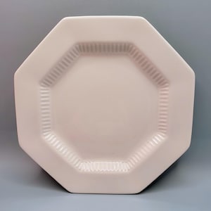May include: White octagonal ceramic plate with a raised rim and a textured design.