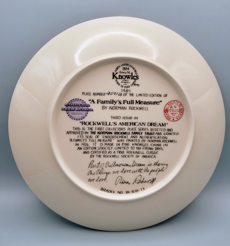 Puede incluir: Un plato de cer&aacute;mica blanco con un borde dorado y una imagen impresa de una familia. El plato forma parte de la serie "Rockwell's American Dream", autenticado por el Norman Rockwell Family Trust. El n&uacute;mero del plato es 2501B y el texto "A Family's Full Measure" est&aacute; impreso en el plato.