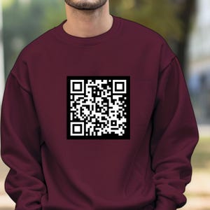 Peut inclure: Un sweat-shirt bordeaux avec un code QR noir et blanc imprimé sur le devant.