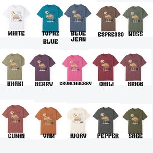 May include: A graphic t-shirt design featuring a spooky Halloween scene with a witch's cauldron, bats, and a full moon. The design is available in 15 different colors, including white, topaz blue, blue jean, espresso, moss, khaki, berry, crunchberry, chili, brick, cumin, yam, ivory, pepper, and sage.