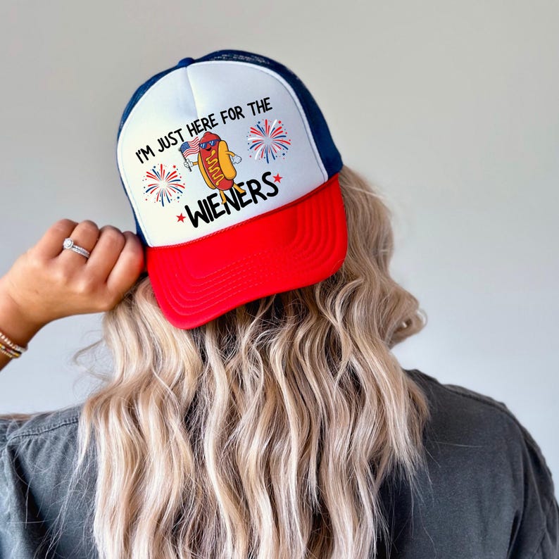 Puede incluir: Una gorra de camionero roja, blanca y azul con un gr&aacute;fico de hot dog y el texto "Solo estoy aqu&iacute; por las salchichas".