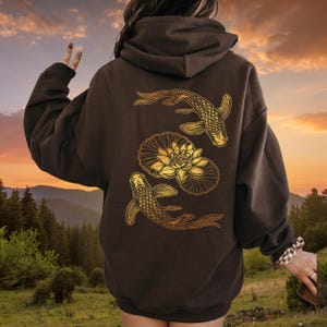 May include: A brown hoodie with a gold graphic of two koi fish swimming around a lotus flower.