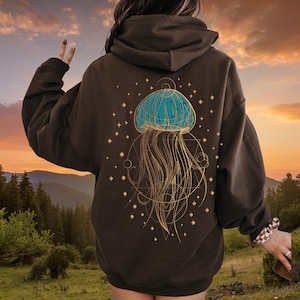 May include: A brown hoodie featuring a graphic of a blue jellyfish with gold accents and a geometric pattern on the back.