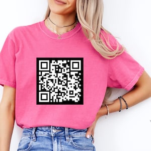 May include: A pink t-shirt with a black and white QR code printed on the front.