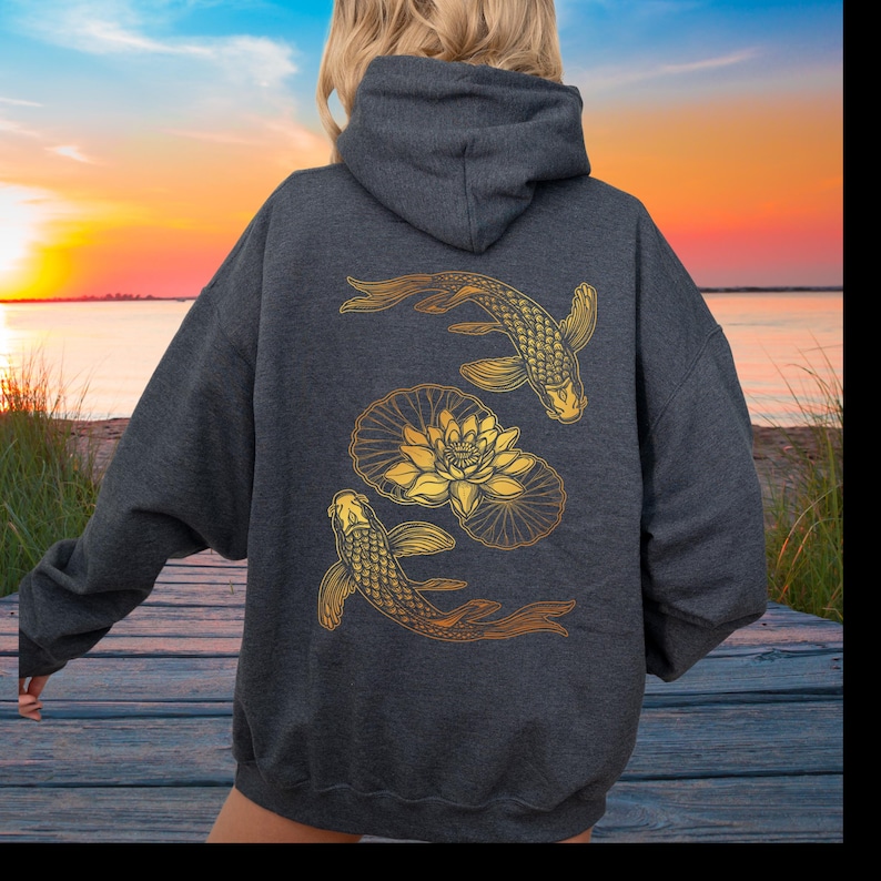 May include: A dark gray hooded sweatshirt with a gold design of two koi fish and a lotus flower on the back.