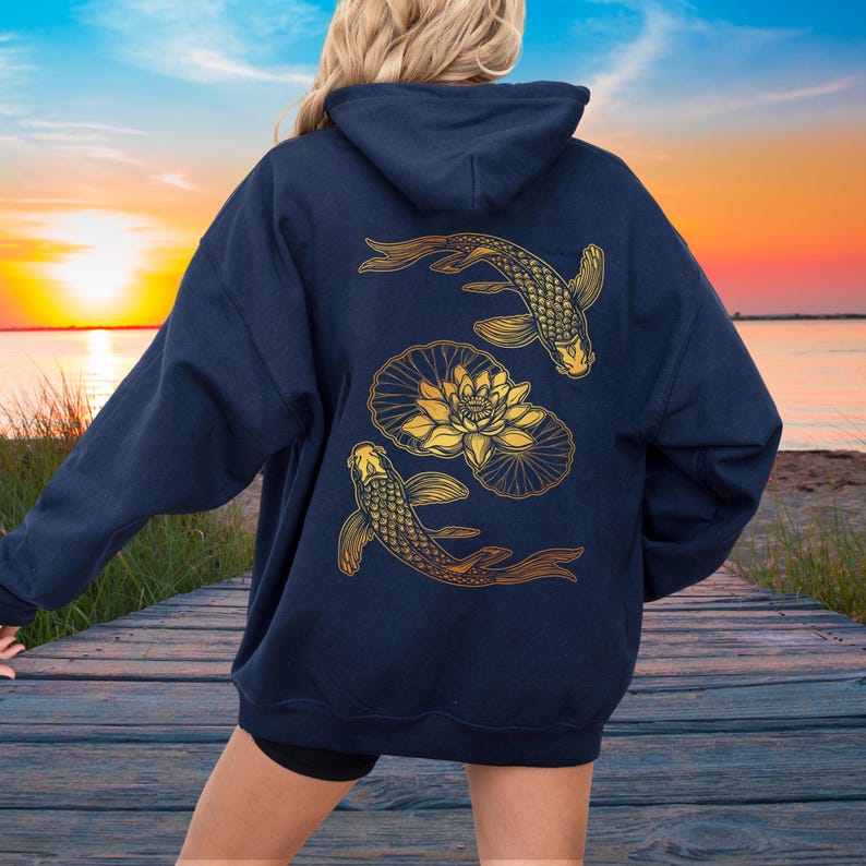 May include: A navy blue hoodie with a gold design of two koi fish swimming around a lotus flower.