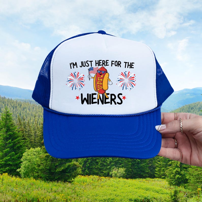 Puede incluir: Una gorra de camionero azul y blanca con el texto "Solo estoy aqu&iacute; por las salchichas" y un dibujo animado de un perrito caliente sosteniendo una bandera estadounidense.