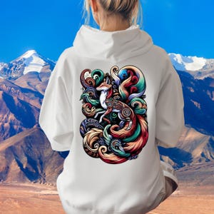 May include: White hoodie with a colorful graphic print of a fox with a swirling tail. The fox is surrounded by intricate patterns and swirls in shades of blue, green, red, and orange.