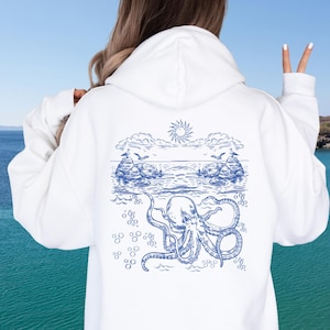 Könnte beinhalten: Weißer Hoodie mit einer blauen Grafik eines Oktopus unter Wasser mit einer Sonne und Wolken über der Wasserlinie.