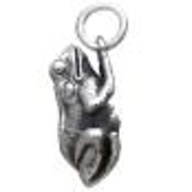 May include: A silver-colored pendant in the shape of a stylized figure, possibly a deity or mythical being. The pendant has intricate details and is suspended from a small ring. The figure is depicted in a seated or kneeling position.