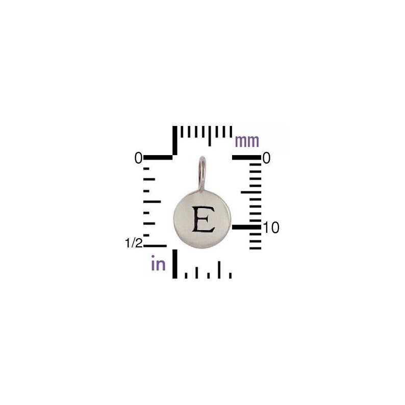以下が含まれることがあります： 丸い銀色のペンダントで、表面に文字「E」が刻まれています。チェーンを取り付けるための小さなループが付いています。ペンダントの直径は約1 cmです。画像には、インチとミリメートルで測定値を示す定規が含まれています。