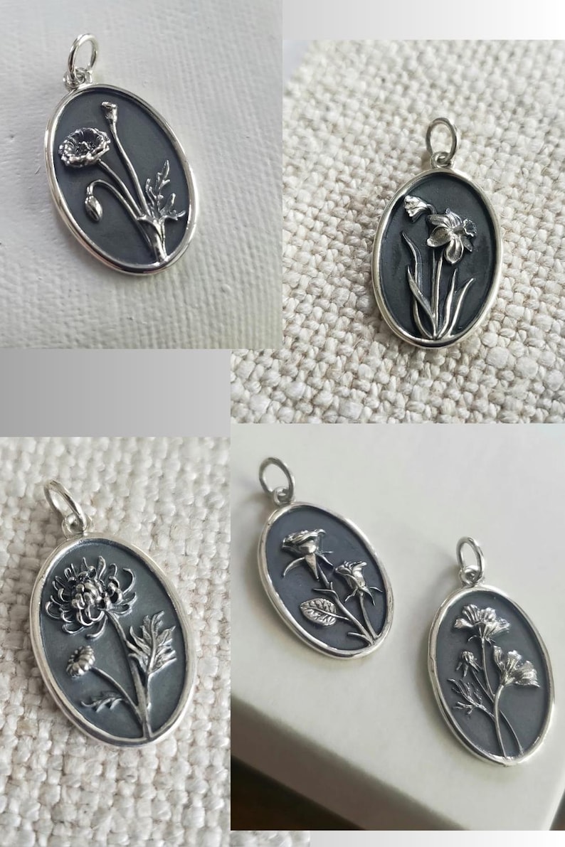 May include: Oval-shaped silver pendants with floral designs. Each pendant features a different flower, including a poppy, daffodil, rose, and other blooms. The pendants have a dark background and a silver border, with a loop at the top for a chain.