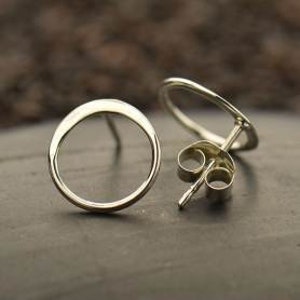 May include: A pair of silver circle stud earrings. The earrings are simple and minimalist, with a smooth, rounded shape.