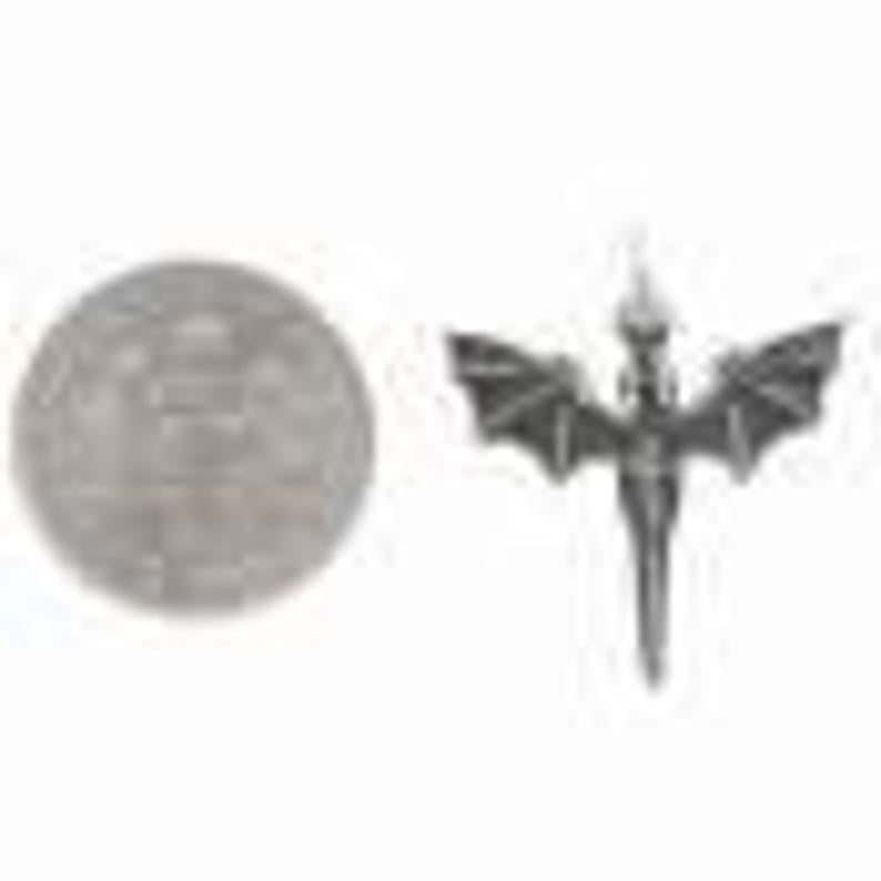 May include: Silver pendant featuring a detailed, winged dragon design with a pointed tail. The dragon is in a standing position with its wings spread out.
