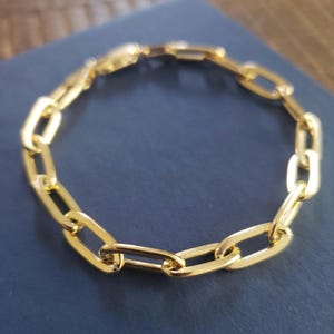 May include: A gold chain bracelet with a classic oval link design.