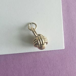 Bronze monkey knot charm Intertwined circles symbol of unity, connection, and resilience, rope