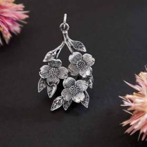 May include: Silver pendant featuring a delicate branch with three stylized flowers and leaves.