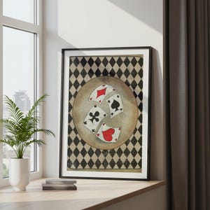 Könnte beinhalten: Ein gerahmter Kunstdruck mit Spielkarten. Das Kunstwerk zeigt vier Spielkarten: eine Karo, eine Pik, eine Kreuz und ein Herz, vor einem beigen kreisförmigen Hintergrund. Der Hintergrund ist ein schwarz-weißes Rautenmuster.
